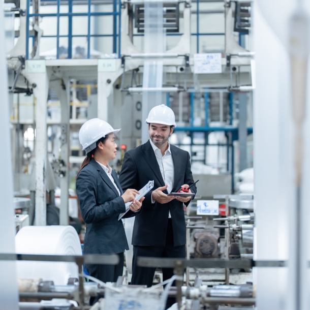 Construction product manufacturing professionals reviewing production data in a factory to support EPD creation, LCA reporting and embodied carbon decarbonization with One Click LCA